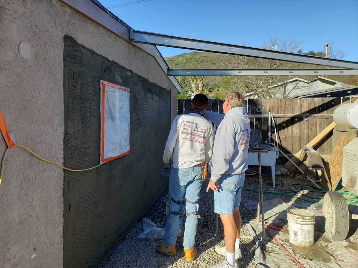 Scratch coat being applied during a stucco job